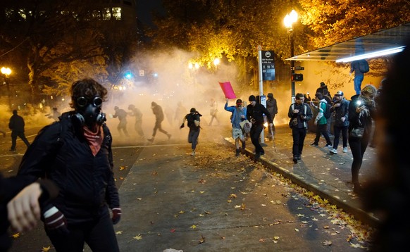 People try to move away from a gas cloud during a protest against the election of Republican Donald Trump as President of the United States in Portland, Oregon, U.S. November 12, 2016. REUTERS/William ...