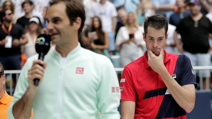 John Isner, right, listens as Roger Federer, of Switzerland, speaks following the singles final of the Miami Open tennis tournament, Sunday, March 31, 2019, in Miami Gardens, Fla. Federer won. (AP Pho ...