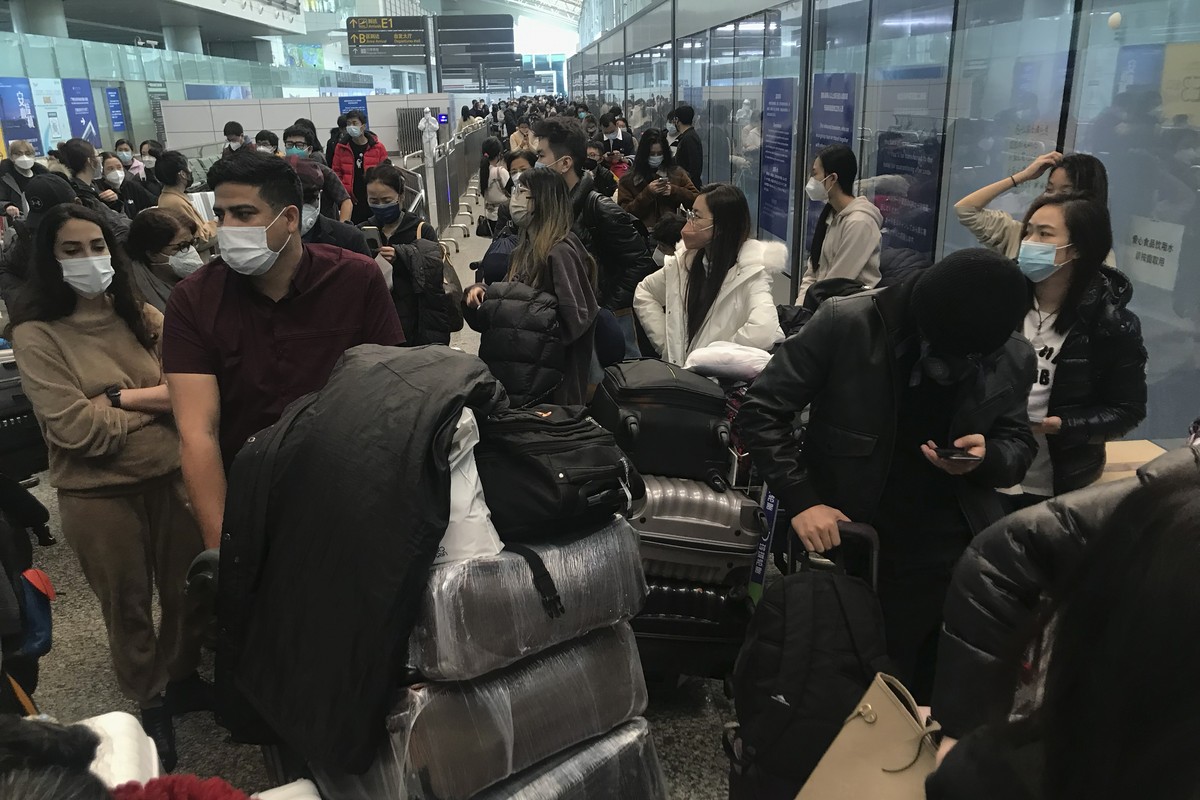 Inbound travelers wait for hours to board buses to leave for quarantine hotels and facilities from Guangzhou Baiyun Airport in southern China's Guangdong province on Dec. 25 2022. China will drop ...
