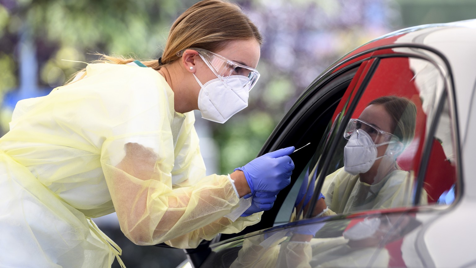 ARCHIVBILD ZU DEN NEUSTEN BESTAETIGTEN CORONAVIRUS-FAELLEN IN DER SCHWEIZ, AM MONTAG, 3. AUGUST 2020 - A health worker collects a nose swab sample for a polymerase chain reaction (PCR) test at a drive ...