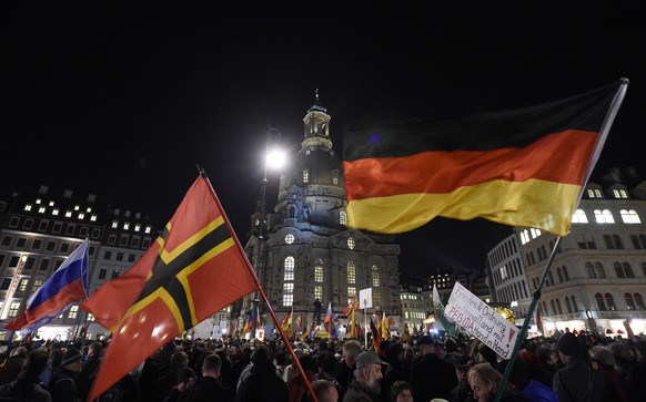 FILE - In this Nov. 2, 2015 file picture demonstrators wave several flags during a demonstration of PEGIDA (Patriotic Europeans against the Islamization of the West) in Dresden, eastern Germany. The r ...