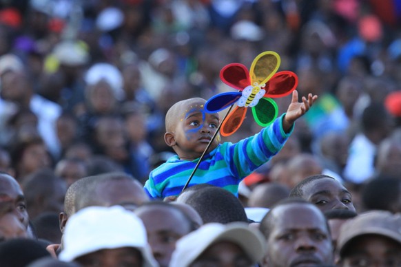 A child is seen during a car draw competition in Harare, Saturday, June, 7, 2014. Thousands of people across Zimbabwe thronged the Borrowdale race course for a chance to win one of the 43 cars that we ...