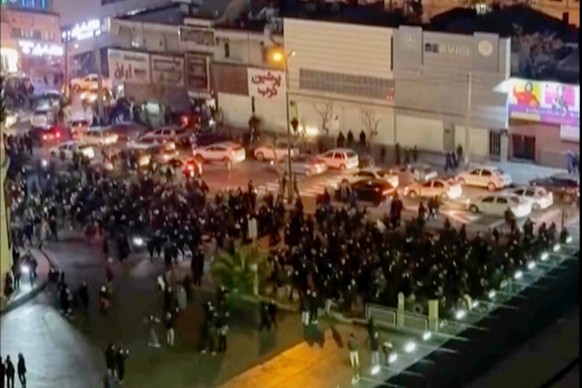 In this frame grab from video taken by an individual not employed by The Associated Press and obtained by the AP outside Iran shows people blocking an intersection during a protest in Tehran, Iran, Th ...