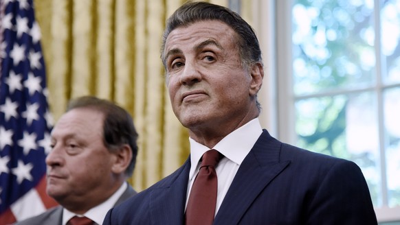 epa06760918 Actor Sylvester Stallone looks on as US President Donald J. Trump signs an Executive Grant of Clemency for former heavyweight champion Jack Johnson in the Oval Office of the White House in ...