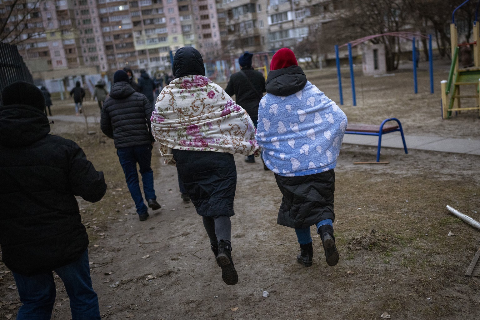 People run to take shelter while the sirens sound announcing new attacks in the city of Kyiv, Ukraine, Friday, Feb. 25, 2022. (AP Photo/Emilio Morenatti)