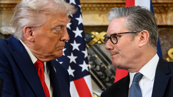 U.S. President Donald Trump, left, and British Prime Minister Keir Starmer look at each other as they shake hands during a press conference at Chequers near Aylesbury, England, Thursday Sept. 18, 2025 ...