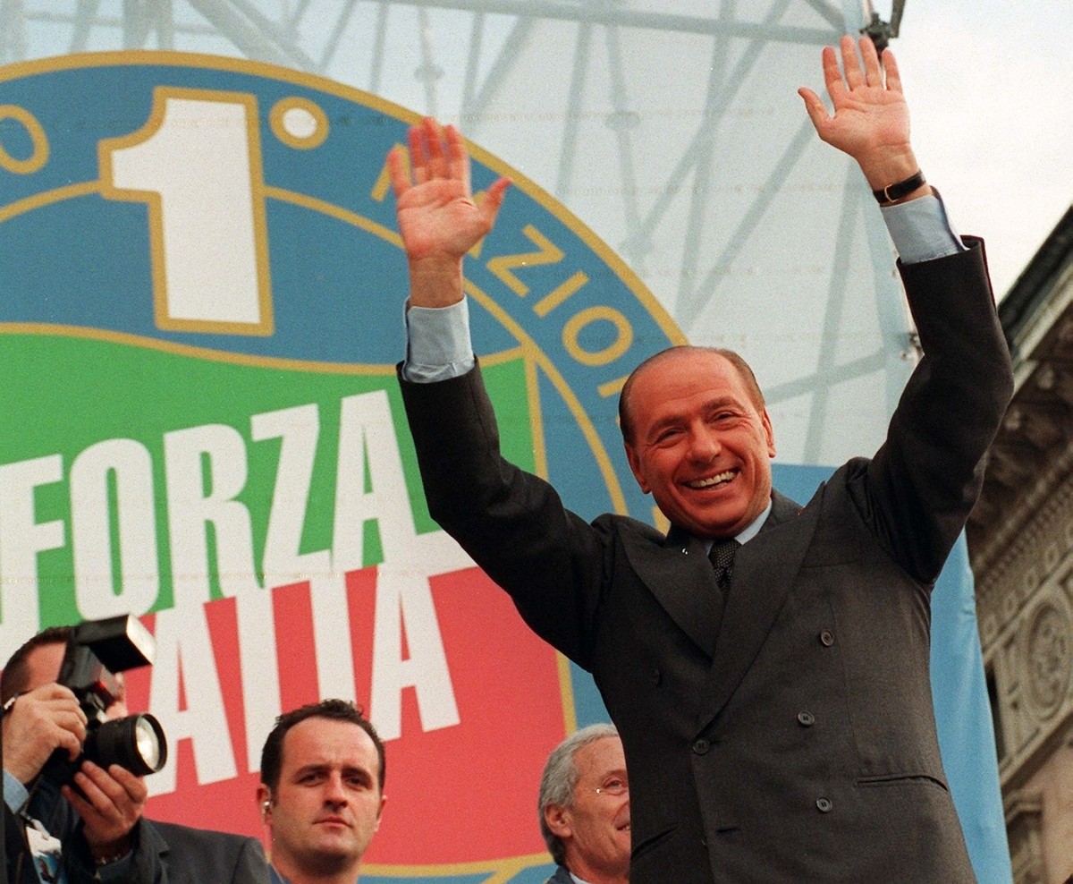 Newly re-elected President of Forza Italia (Let's Go Italy) party Silvio Berlusconi waves to his supporters during a party rally in downtown Milan's Duomo square, concluding the first nation ...