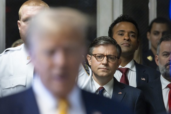 U.S. Speaker of the House Mike Johnson, center, and businessman Vivek Ramaswamy listen as former President Donald Trump, left, talks with reporters as he arrives at Manhattan criminal court in New Yor ...
