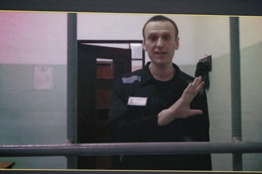 FILE - Russian opposition leader Alexei Navalny, is seen on a TV screen as he appears in a video link provided by the Russian Federal Penitentiary Service from the colony in Melekhovo, Vladimir region ...