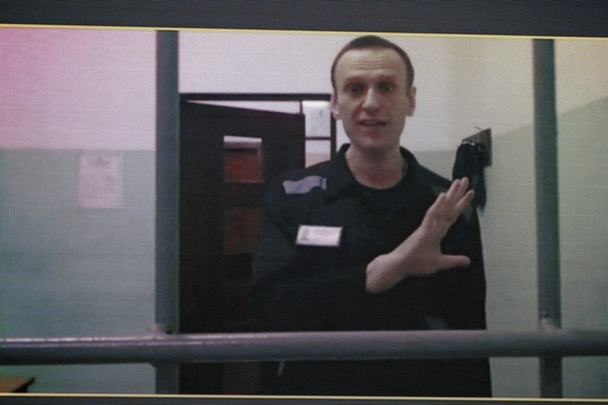 FILE - Russian opposition leader Alexei Navalny is seen on a TV screen as he appears in a video link from the Russian Federal Penitentiary Service from the colony in Melekhovo, Vladimir region...