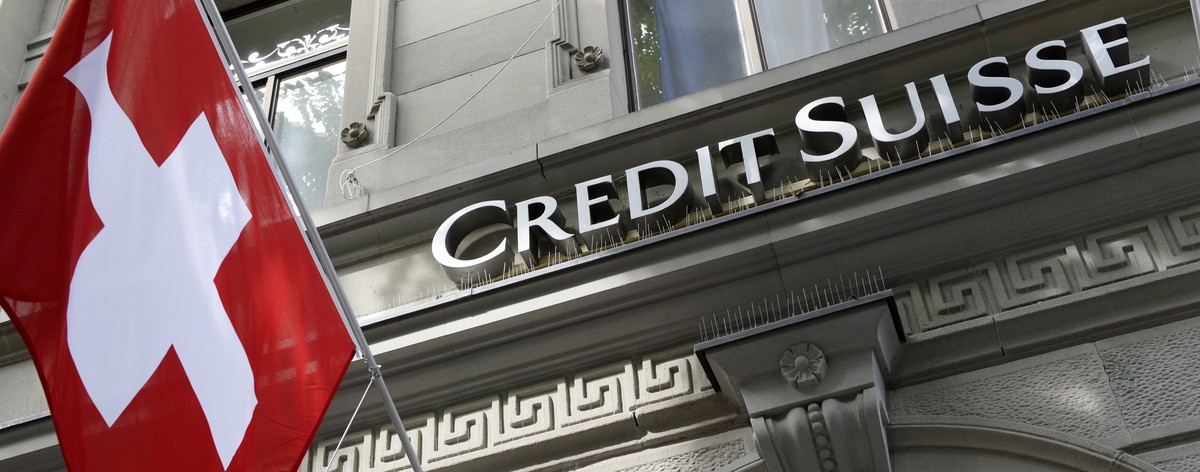 FILE - This Aug. 1, 2014 file photo shows the logo of Swiss bank Credit Suisse and a Swiss flag in Zurich, Switzerland. Credit Suisse said Tuesday that a senior executive and the head of its security  ...