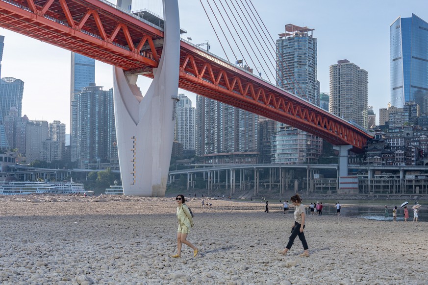 epa10131494 People walk on the dried out riverbed of the Jialing River, a major tributary of the Yangtze River, in Chongqing, China, 21 August 2022. China is experiencing its most severe drought and l ...