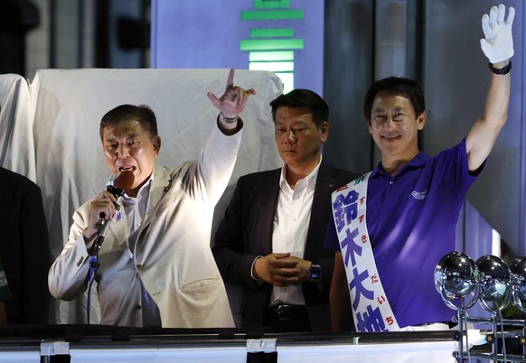 epa12247369 Japanese Prime Minister and President of the ruling Liberal Democratic Party Shigeru Ishiba (L) gives a speech in support of a candidate on the last day of campaigning for the 2025 House o ...