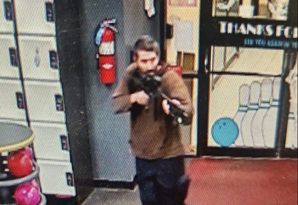 In this image taken from video released by the Androscoggin County Sheriff&#039;s Office, an unidentified gunman points a gun while entering Sparetime Recreation in Lewiston, Maine, on Wednesday, Oct. ...
