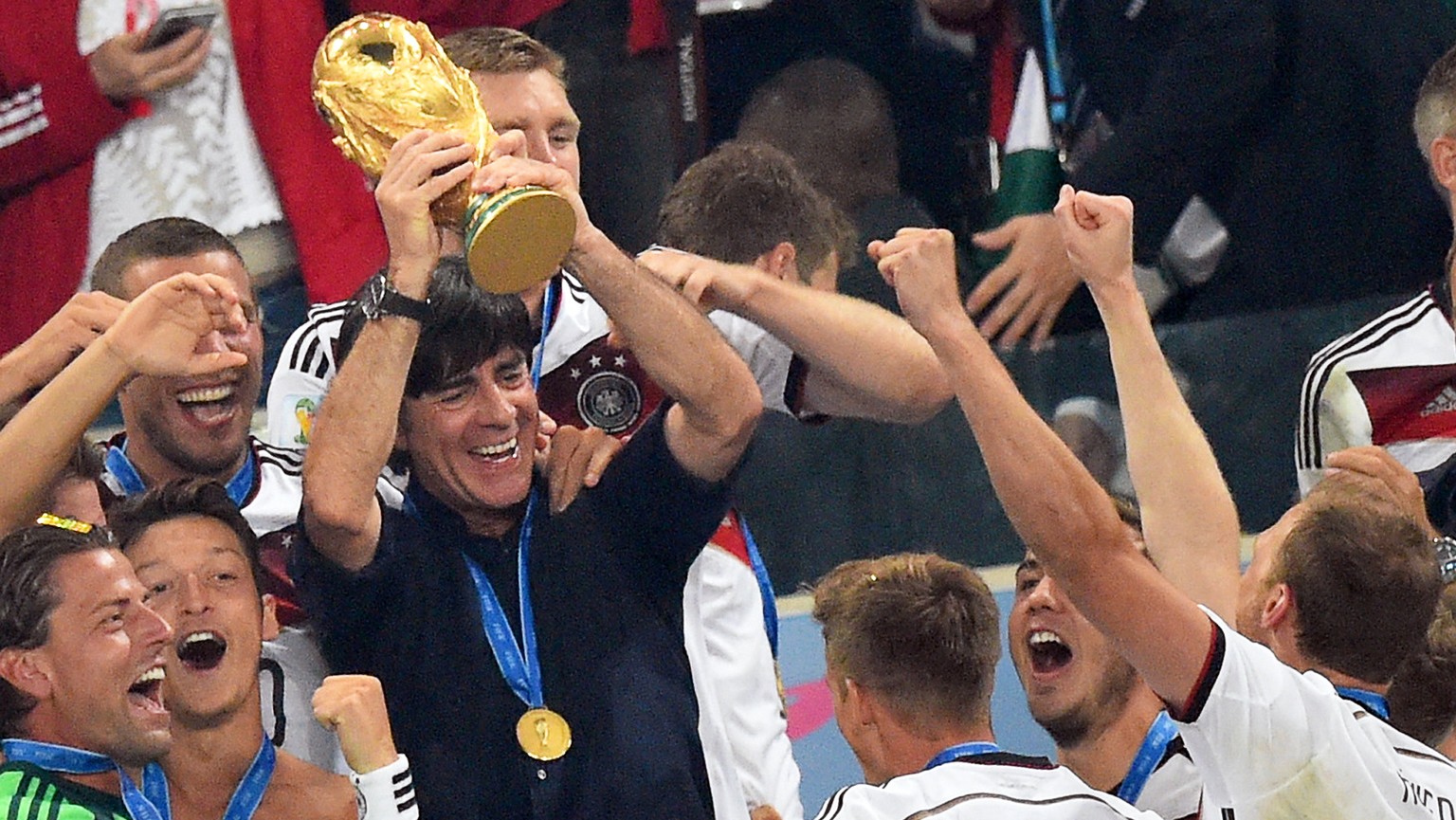 epa09063325 (FILE) - Germany's head coach Joachim Loew (C) lifts the World Cup trophy as his teammates celebrate after winning the FIFA World Cup 2014 final between Germany and Argentina at the Estadi ...