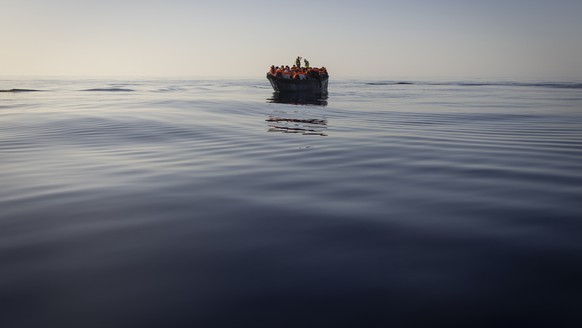 FILE - Migrants with life jackets provided by volunteers of the Ocean Viking, a migrant search and rescue ship run by NGOs SOS Mediterranee and the International Federation of Red Cross (IFCR), still  ...