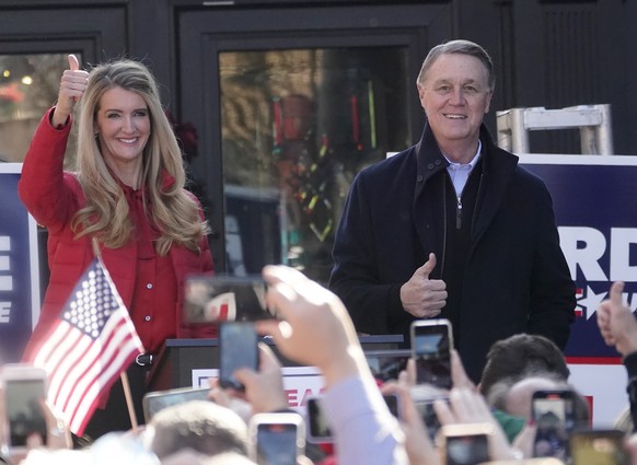 Sen. Kelly Loeffler, R-Ga., left, stands with Sen. David Perdue, R-Ga., and Ivanka Trump, Assistant to the President, during a campaign rally, Monday, Dec. 21, 2020, in Milton, Ga. (AP Photo/John Baze ...