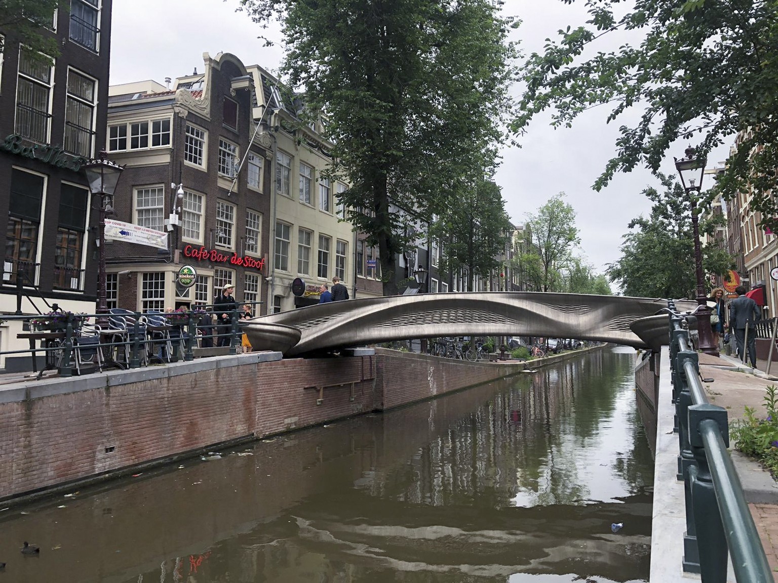 A steel 3D-printed pedestrian bridge spans a canal in the heart of the red light district in Amsterdam, Netherlands, Thursday, July 15, 2021. The distinctive flowing lines of the 12-meter (40-foot) br ...