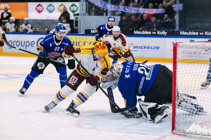 Christoph Bertschy (HCFG), gauche, lutte pour le puck avec PostFinance Top Scorer Markus Granlund (GSHC), centre, et Reto Berra (HCFG), droite, lors du match du championnat suisse de hockey sur glace  ...
