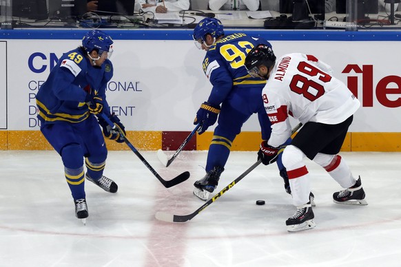 epa05972827 Cody Almond of Switzerland in action against Victor Rask (L) and Gabriel Landeskog of Sweden during the IIHF Ice Hockey World Championship 2017 quarter final game between Switzerland and S ...