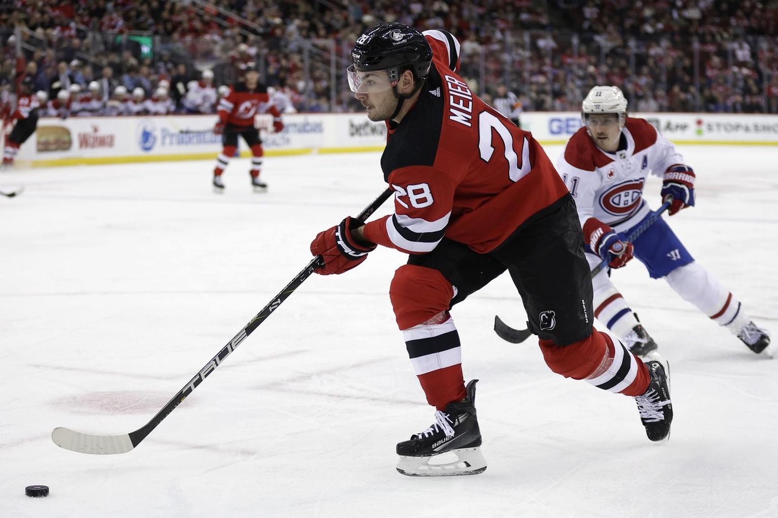 New Jersey Devils right wing Timo Meier (28) controls the puck past Montreal Canadiens right wing Brendan Gallagher during the second period of an NHL hockey game Wednesday, Jan. 17, 2024, in Newark,  ...