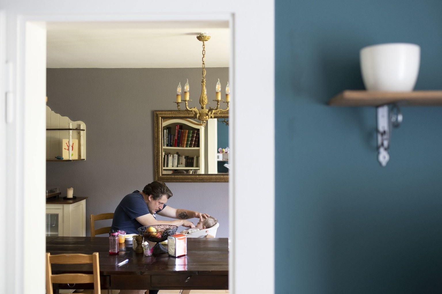 A father feeds his six-month-old daughter porridge at home on his day off, photographed on May 19, 2020 in Zurich.  (KEYSTONE/Christian Beutler)