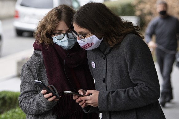 Nadia Kuhn, GSoA Sekretaerin, links, und Julia Kueng, Co Praesidentin der Jungen Gruenen Schweiz vom Ja Komitee zur Kriegsgeschaefte Initiative konsultieren ihre Handys am Sonntag, 29. November 2020,  ...