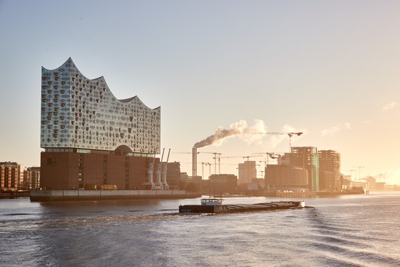 26.02.2022, Hamburg: Ein Lastschiff f�hrt auf der Elbe im Hafen an der Elbphilharmonie flussaufw�rts vorbei. Foto: Georg Wendt/dpa +++ dpa-Bildfunk +++