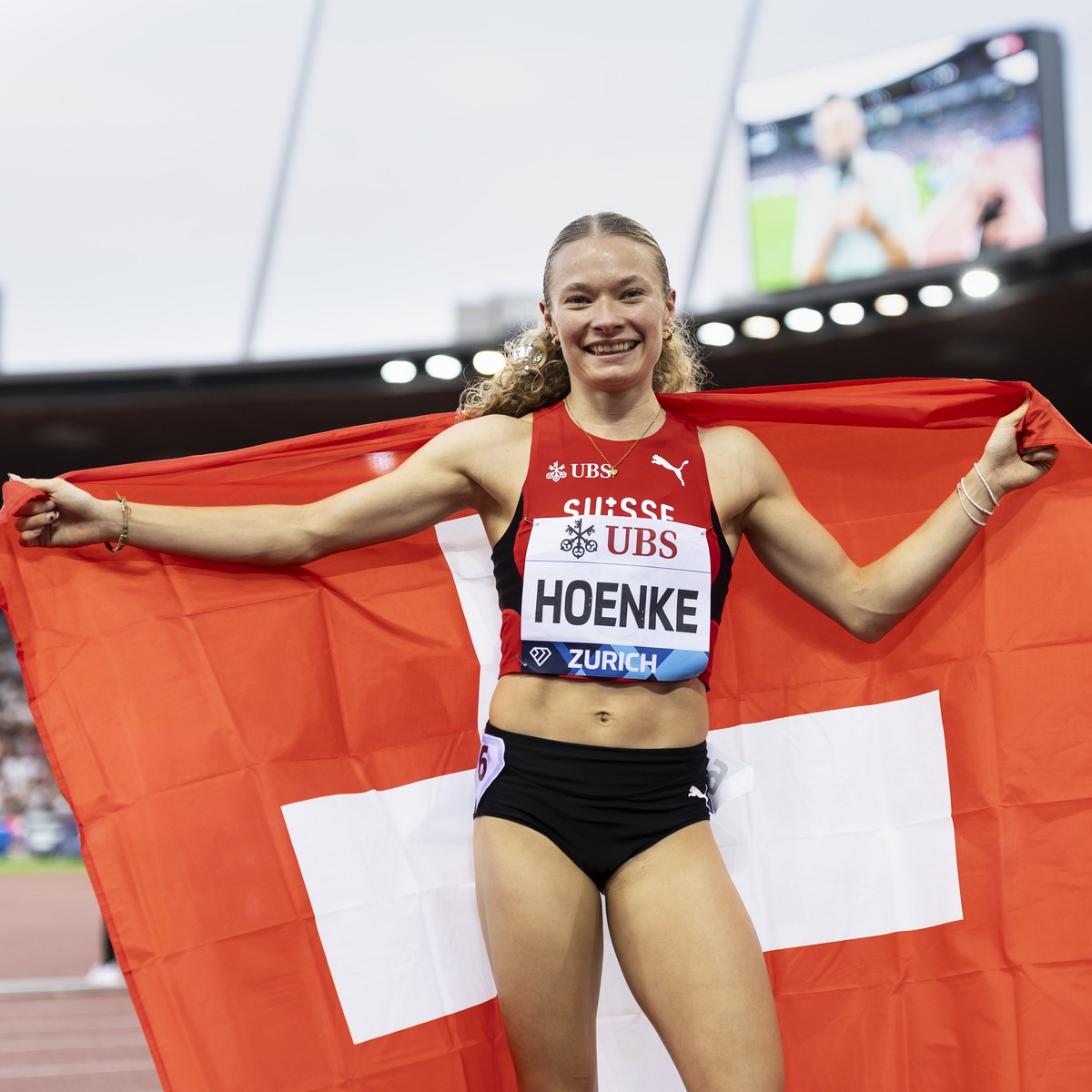 Fabienne Hoenke of Switzerland celebrates with a Swiss flag after winning the 200 meters women, during the World Athletics Diamond League Weltklasse Zurich athletics meeting at the Letzigrund stadium  ...
