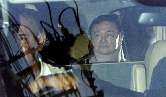 Former Thai Prime Minister Thaksin Shinawatra, right, sits in a vehicle in front of his residence after being released on parole, Sunday, Feb. 18, 2024, in Bangkok, Thailand. Thaksin was released from ...