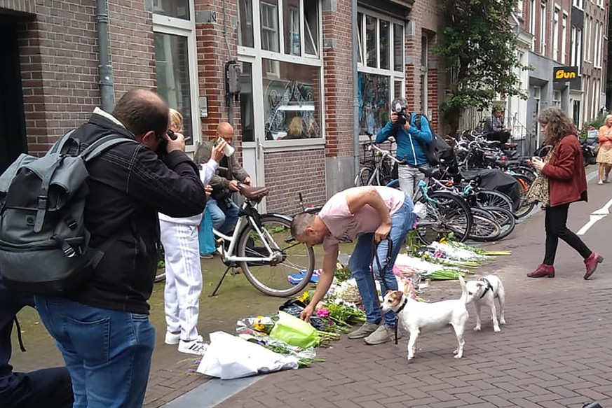 A man places flowers where journalist Peter R. de Vries has been shot, Wednesday, July, 7, 2021 in Amsterdam. Peter R. de Vries, who is widely lauded for fearless reporting on the Dutch underworld, wa ...