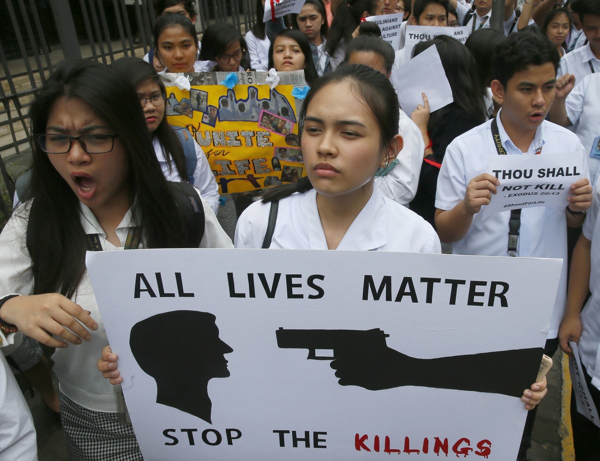 Students from St. Paul's University, a Roman Catholic university, display placards as they come out from their campus to protest the killings being perpetrated in the unrelenting "War on Dru ...