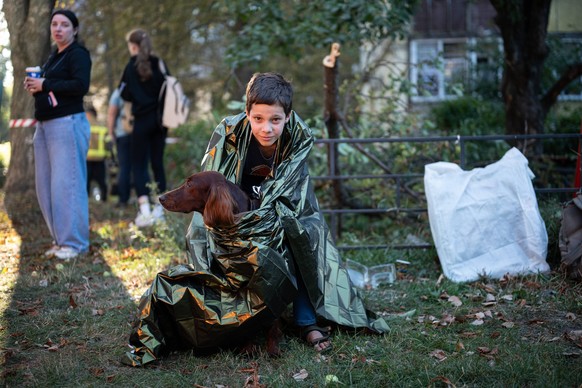 Ukraine says 12 people killed, 33 injured in Russia s overnight strike on Kyiv KYIV, UKRAINE - AUGUST 20: A boy holds a dog while wrapped in an emergency blanket following an overnight Russian attack  ...