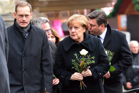 epa05683631 (L-R) Berlin Mayor Michael Mueller, German Interior Minister Thomas de Maiziere, German Chancellor Angela Merkel, and Berlin Interior Senator Andreas Geisel visit the scene of an attack on ...