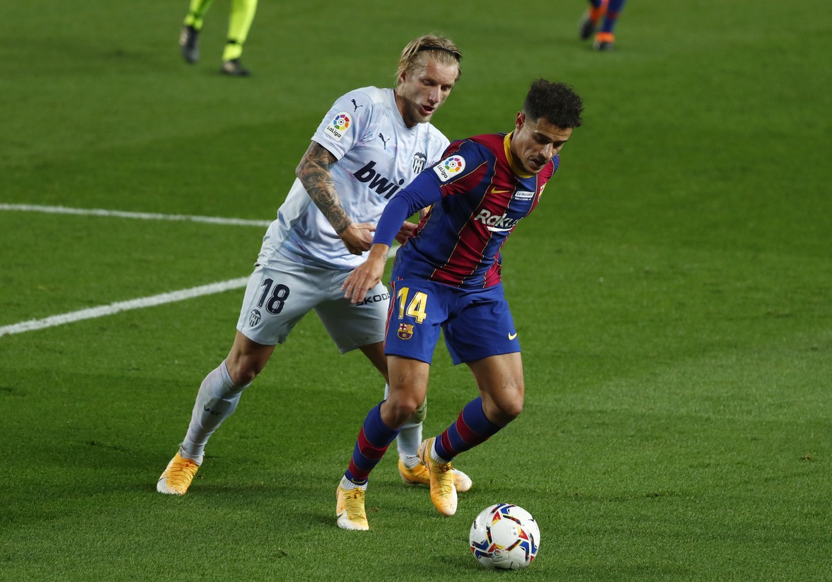 Barcelona's Philippe Coutinho, right fends off the challenge of Valencia's Daniel Wass during the Spanish La Liga soccer match between Barcelona and Valencia at the Camp Nou stadium in Barce ...