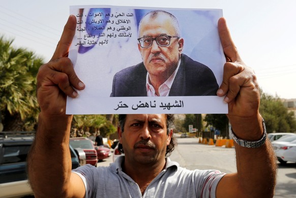 A relative of the Jordanian writer Nahed Hattar holds his picture during a sit-in in the town of Al-Fuheis near Amman, Jordan, September 25, 2016. REUTERS/Muhammad Hamed FOR EDITORIAL USE ONLY. NO RES ...