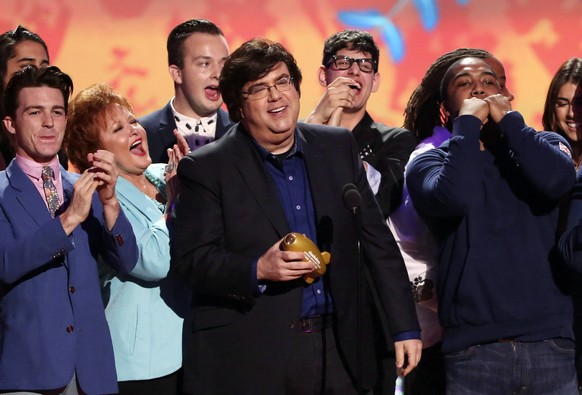 FILE - Dan Schneider, center, accepts an award in Los Angeles. Schneider sued the makers of ?Quiet on Set: The Dark Side of Kids TV? on Wednesday, May 1, 2024, alleging the makers of the documentary s ...