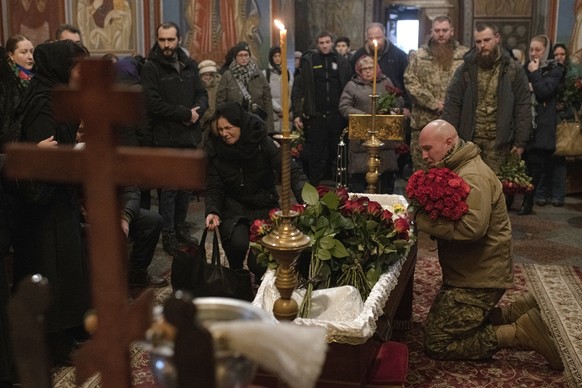 Relatives, friends, and comrades mourn next to the coffin of Ukrainian serviceman Sergii Myronov, killed fighting Russian troops in Donetsk region, during a funeral ceremony at St. Michael&#039;s Gold ...