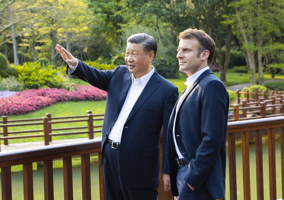 epa10564460 Chinese President Xi Jinping (L) and French President Emmanuel Macron (R) chat during a stroll through the Pine Garden in Guangzhou, Guangdong Province, China, 07 April 2023 (issued 08 Apr ...