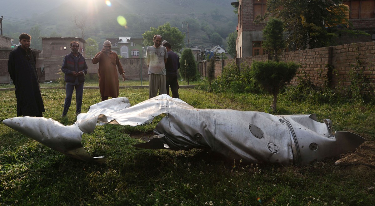 epa12079115 People stand near the damaged part of an unidentified aircraft at a Mosque compound in Pampore, in the outskirts of Srinagar, India, 07 May 2025. On 07 May, the Indian Armed Forces launche ...
