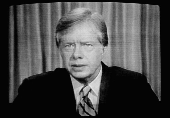 FILE - President Jimmy Carter is shown on a video screen as he addresses the nation on the failed attempt to rescue the American hostages in Iran, April 25, 1980. (AP Photo/Mark Wilson, File)