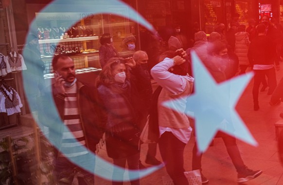 epa09664761 People are seen through a reflection of Turkish flag as they do shopping at Grand Bazaar in Istanbul, Turkey, 03 January 2022. According to the Turkish Statistical Institute, Turkish infla ...