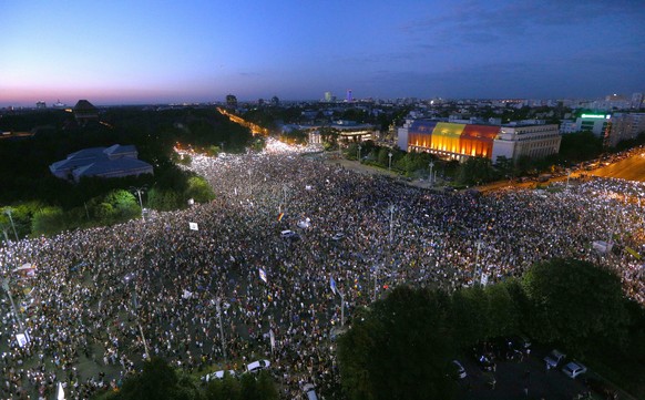 epaselect epa06941840 General view of Victoriei square, taken while demonstrators light-up their smart-phones, during a protest of expatriates against the leftist government, held in front of the gove ...