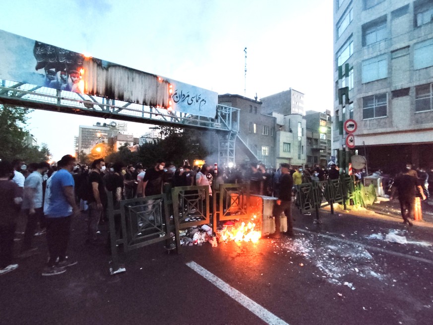 epa10197705 People clash with police during a protest following the death of Mahsa Amini, in Tehran, Iran, 21 September 2022. Mahsa Amini, a 22-year-old Iranian woman, was arrested in Tehran on 13 Sep ...