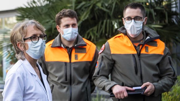 Swiss civil protection members wearing a surgical mask listen to instructions from doctor Valerie Klein, center, during a media presentation at the Morges Hospital &quot;Hopital de Morges&quot; during ...