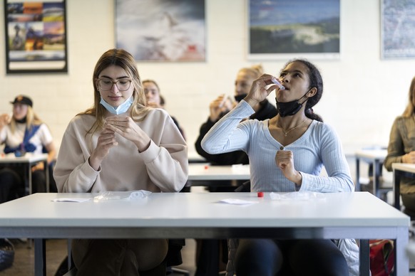 Waehrend eines Corona PCR-Speichelpooltests in der Klasse 6D an der Kantonsschule Wiedikon nehmen Schuelerinnen und Schueler eine salzige Fluessigkeit fuer eine Minute in den Mund um Speichel zu samme ...