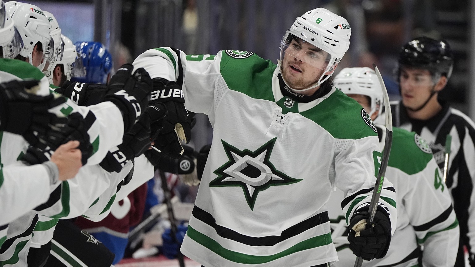 Dallas Stars defenseman Lian Bichsel is congratulated as he passes the team box after he scored the winning goal as time ran out in an NHL preseason hockey game against the Colorado Avalanche, Monday, ...