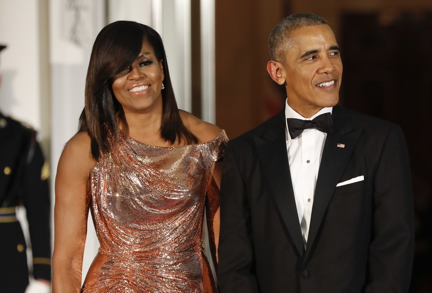 FILE - In this Oct. 8, 2016 file photo, President Barack Obama and first lady Michelle Obama wait to greet Italian Prime Minister Matteo Renzi and his wife Agnese Landini for a State Dinner at the Whi ...