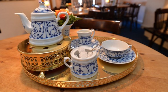 epa05292056 A tray with a teapot, cup, rock sugar, and tea cream sits on a table in a tea house in Schnoor, the medieval city district in Bremen, Germany, 06 May 2016. East Frisian tea culture will be ...