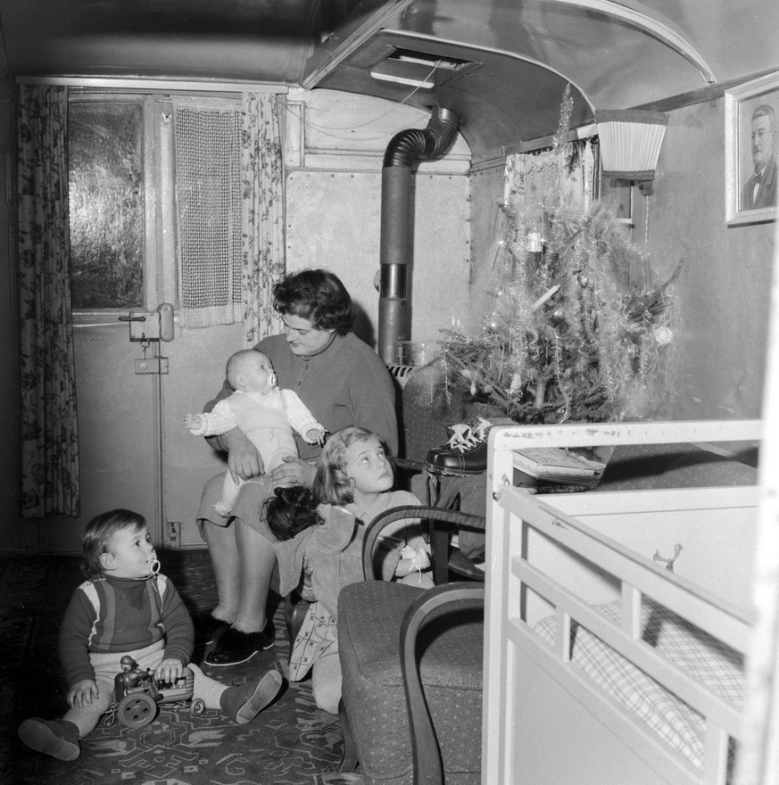 A mother celebrates Christmas with her three children in a trailer, pictured in Switzerland, on December 25, 1953. The girl was given a doll and her younger brother a tractor, furthermore a new pair o ...